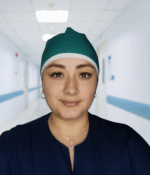 Gorro unisex verde jade antifluido con borde y cordón blanco, usado por una persona de perfil sobre fondo claro.”