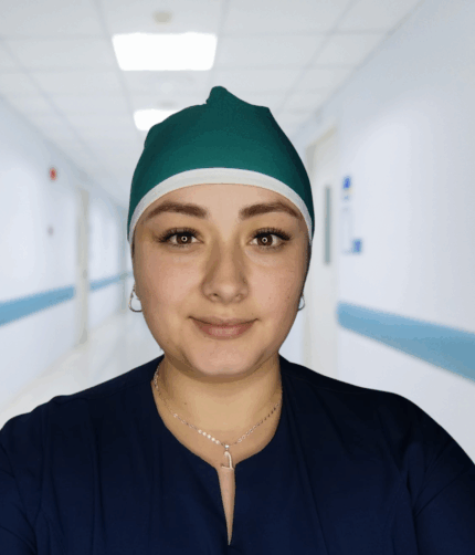 Gorro unisex verde jade antifluido con borde y cordón blanco, usado por una persona de perfil sobre fondo claro.”