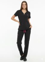 Mujer posando con un uniforme médico de dos piezas en color negro: filipina de cuello en V con detalles fucsia y pantalón tipo cargo con cordón ajustable.